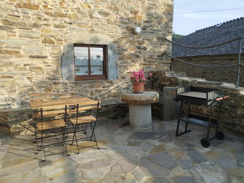 a stone patio with a table and a piano at Casa Mameleiro e Casa Kintal in A Pontenova