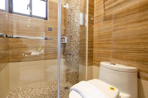 a bathroom with a toilet and a glass shower at Meet in Dongshan Homestay in Dongshan