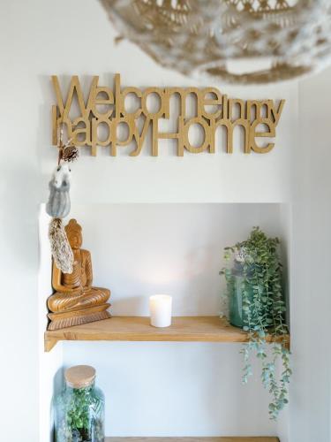 a shelf with a happy birthday home sign at L'Oxalis villa (Le Cocon) in Bullion