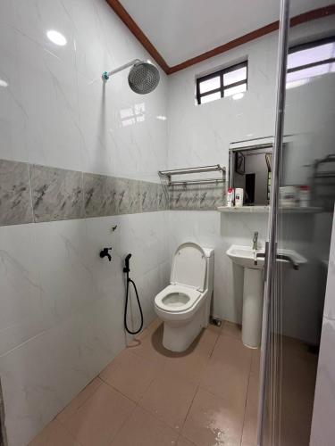 a bathroom with a toilet and a sink at Sha Homestay in Marang