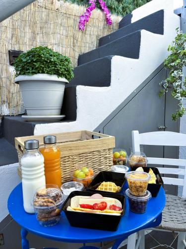un tavolo blu con vassoio di cibo e bevande di Villa Sertis Santorini a Imerovigli