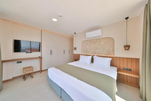 a bedroom with a large bed and a tv at Lyxos Hotel in Kas