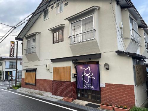 a building with a purple banner on the side of it at Hot Spring Inn Hyoutan in Kusatsu