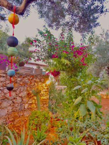 a garden with flowers and a stone wall at Jenoa, sealight house in Agios Nikolaos