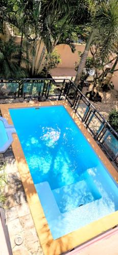 a large swimming pool with blue water and palm trees at Villa centre Grand Baie in Grand Baie