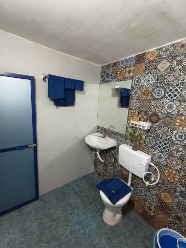 a bathroom with a toilet and a sink at Krishna Garden and Resort in Betgaon
