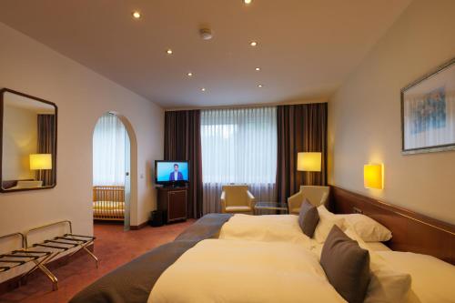 a hotel room with two beds and a television at Trip Inn Hotel Esplanade, Düsseldorf in Düsseldorf