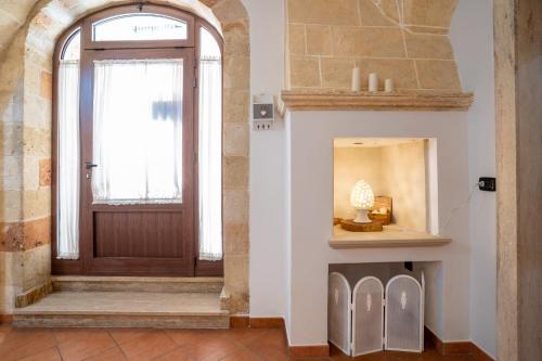 a hallway with a wooden door and a fireplace at LA ULIA by SALENTO OASIS in Copertino