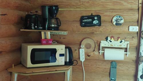 a microwave sitting on top of a wooden wall at Koivula Fish Cottage in Savonlinna
