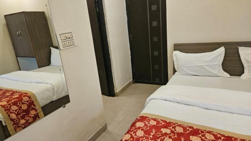 una camera con due letti e uno specchio di Bluebells Varanasi a Varanasi