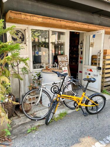 Dos bicicletas estacionadas frente a una tienda de vinos. en 2no HOME & PARK, en Kobe