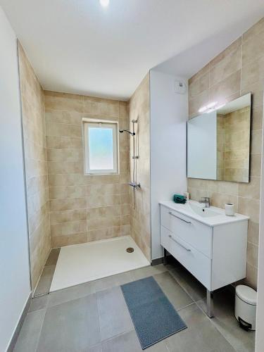 une salle de bain avec une baignoire, un lavabo et un miroir dans l'établissement Nice apartment with garden direct access to beach,Parking free, à Vias