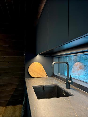 a kitchen with a sink and a wooden cutting board at Villa Pikku Karhu in Kuusamo