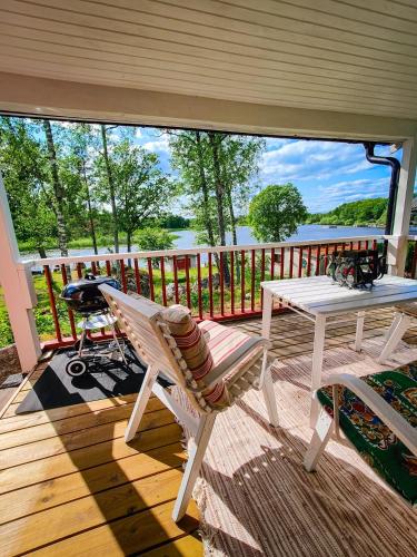 a porch with a chair and a table and a grill at Roparudden in Kvicksund
