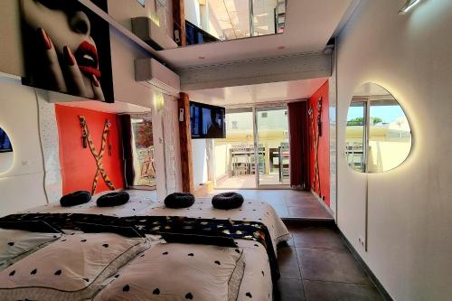 une chambre avec deux lits dans une pièce avec fenêtres dans l'établissement Naturiste Cap d'Agde Phantasme Naturiste Port Nature 314, au Cap d'Agde