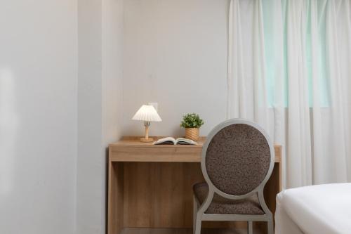 a bedroom with a desk with a chair and a lamp at Home Inn-Wuhan Yellow Crane Tower Epiphyllum Forest Huayi Select Hotel in Wuhan