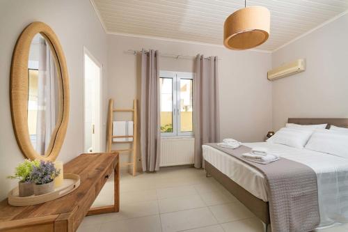 a bedroom with a bed and a mirror and a table at Asmira Apartment by PaxosRetreats in Lákka