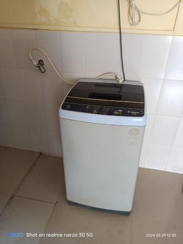 Un pequeño refrigerador en una cocina con un cable. en Bed And Breakfast At Pushpanjali Residency Phase 2 Bunglow No A1 Owale Ghodbunder Road Thane West, en Thane