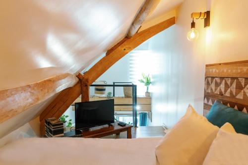 a bedroom with a bed and a tv in a room at L'Oxalis villa (Le Cocon) in Bullion