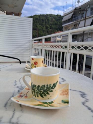 a coffee cup and saucer on a table on a balcony at Casa Miranda in Nafpaktos