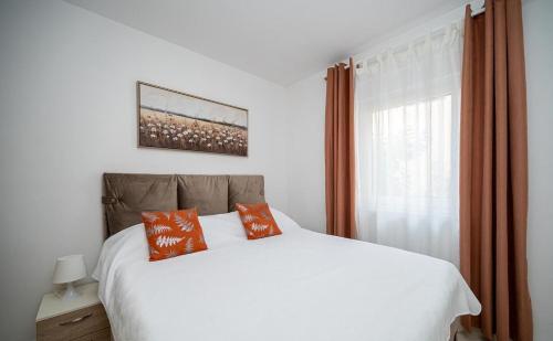 a bedroom with a white bed and a window at Apartments Sanja in Zaton