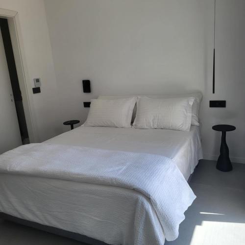 a bedroom with a white bed with white sheets and pillows at Oro suites view in Mýkonos City