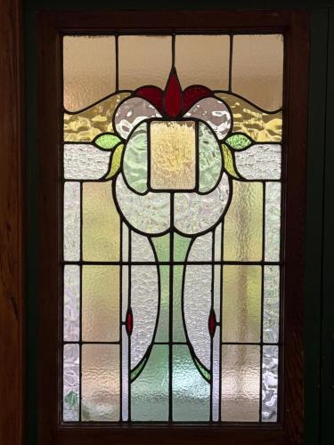 a stained glass window with a cross and flowers at Manor on the Park Backpackers in Dunedin