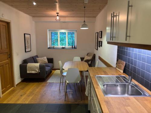 英格堡Genuine mountain holiday apartment in Engelberg的配有桌子和沙发的厨房和客厅