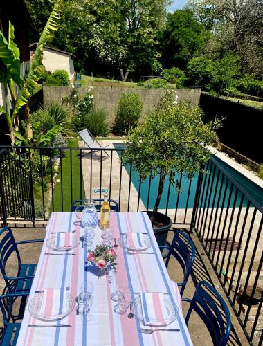- une table avec des verres et des fleurs sur la terrasse dans l'établissement Le Clos des hirondelles, à Veyrignac