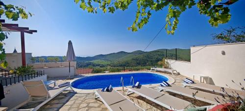 a swimming pool with lounge chairs next to a building at Villa Smoquizza in Smokvica