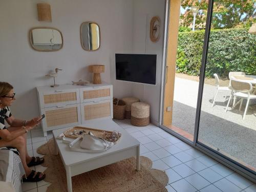 une femme debout dans un salon avec une télévision dans l'établissement Maison entièrement restaurée et meublée à neuf, à Saint Cyprien Plage