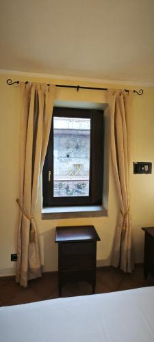 a bedroom with a large window with curtains at Palazzo Cafarelli in Laureana Cilento