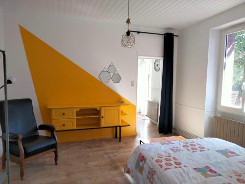 - une chambre avec un bureau, un lit et une chaise dans l'établissement Au jardin Vue viaduc, à Millau