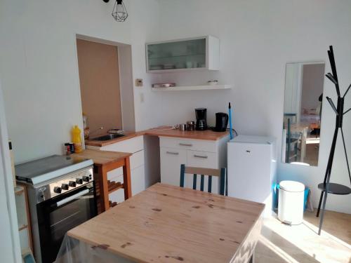 Il comprend une cuisine équipée d'une cuisinière et d'une table en bois. dans l'établissement Au jardin Vue viaduc, à Millau