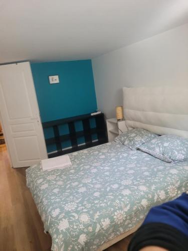 - une petite chambre avec un lit et un mur bleu dans l'établissement Peaceful haven with garden and pool, à Lyon