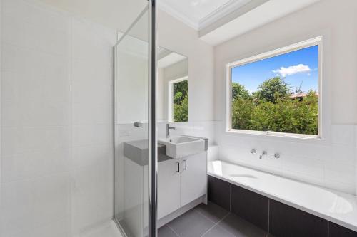 a white bathroom with a sink and a window at Buxton Countryside Home in Buxton