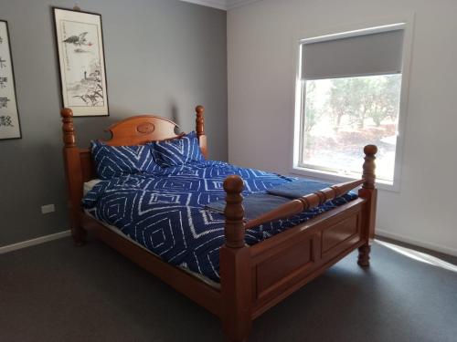a bedroom with a bed with a blue comforter and a window at Buxton Countryside Home in Buxton