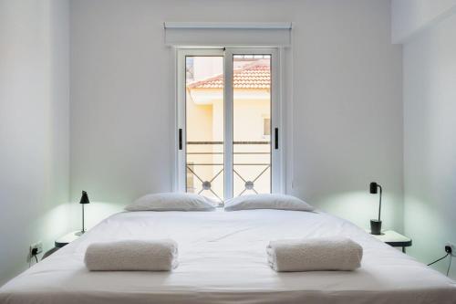 a bedroom with a large white bed with a window at Penthouse Apartment with Amazing View in Kiti in Kiti