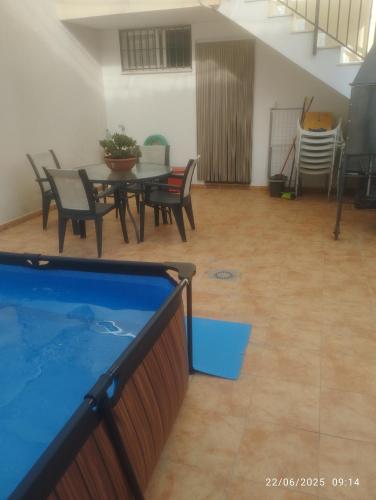 Habitación con piscina, mesa y sillas en Villa Montoro, en Purchil