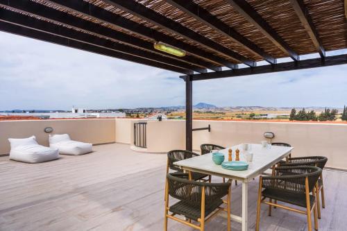 a patio with a table and chairs on a roof at Penthouse Apartment with Amazing View in Kiti in Kiti