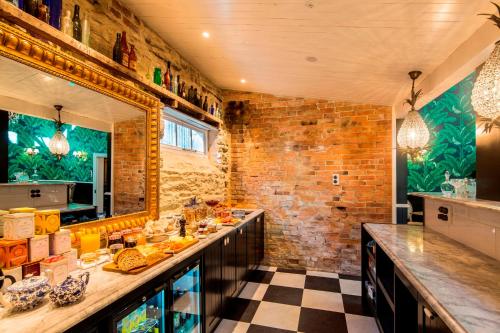 a kitchen with a long counter and a brick wall at Hulbert House Luxury Boutique Lodge Queenstown in Queenstown