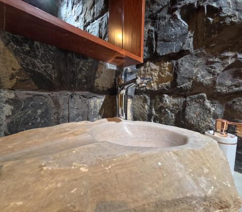 a stone sink in a bathroom with a stone wall at the suwgra-Al-Jabal Al-Akdar in Sūkirah