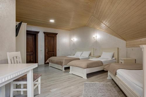a bedroom with two beds and a table and a desk at Premium hotel & SPA in Bukovel