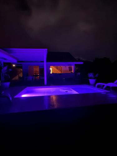 a swimming pool lit up at night with purple lights at Villa Hana'iki in Paui