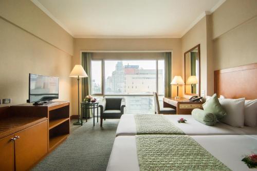 Säng eller sängar i ett rum på Bangkok Palace Hotel
