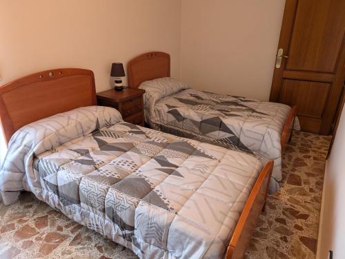 a bedroom with two beds and a night stand at la erilla vieja in Navarrevisca