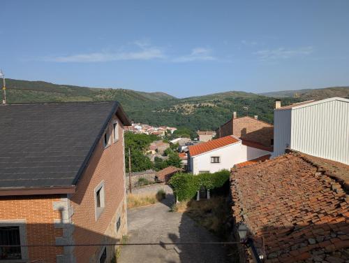 a view of a small town with houses and mountains at la erilla vieja in Navarrevisca