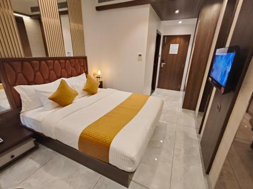 a bedroom with a bed and a flat screen tv at Hotel Ocean Residency Thane West in Thane