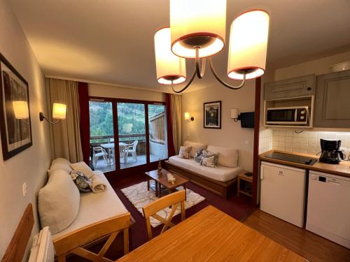 une cuisine et un salon avec un canapé et une table dans l'établissement Magnifique appartement pour 5 personnes grande terrasse sud vue panoramique, plein soleil, calme havre de paix et de détente, à Isola