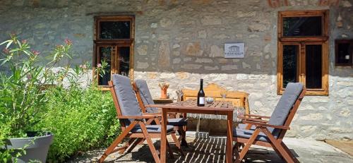a wooden table and chairs in front of a building at Karádi-Berger Vendégház in Erdőbénye